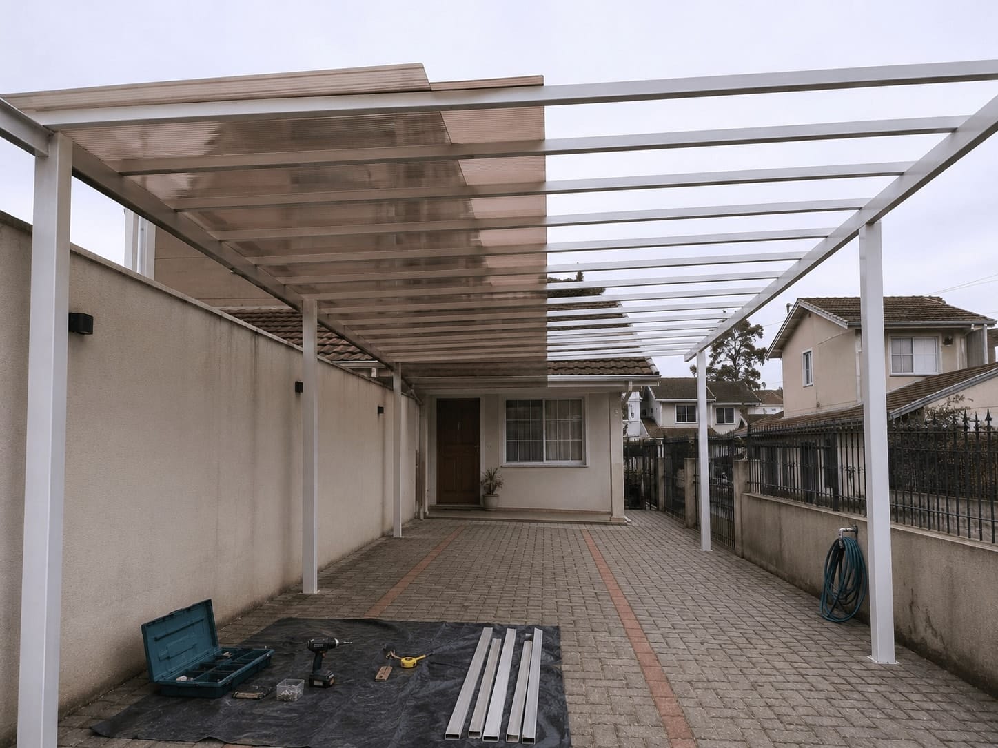 Instalação parcial de cobertura de policarbonato sobre garagem residencial