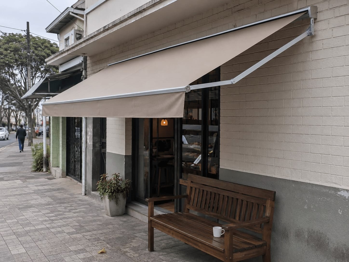 Toldo de lona instalado sobre entrada de pequeno café em Curitiba
