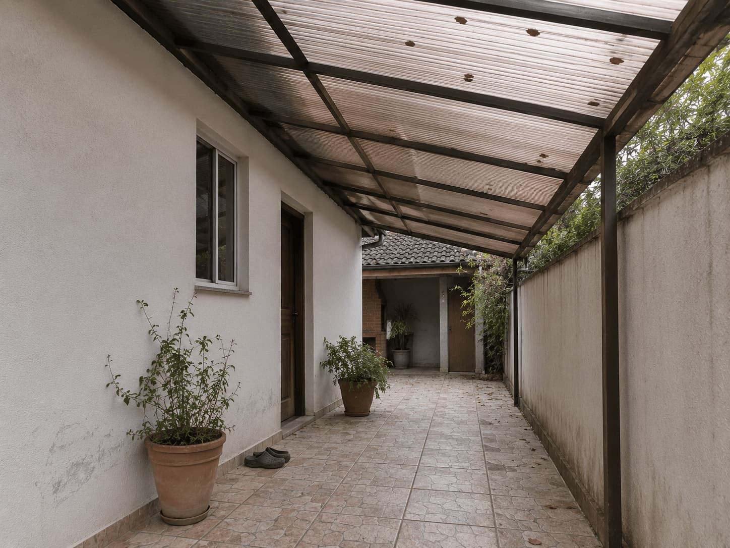 Telhado de policarbonato bronze cobrindo passagem lateral de residência