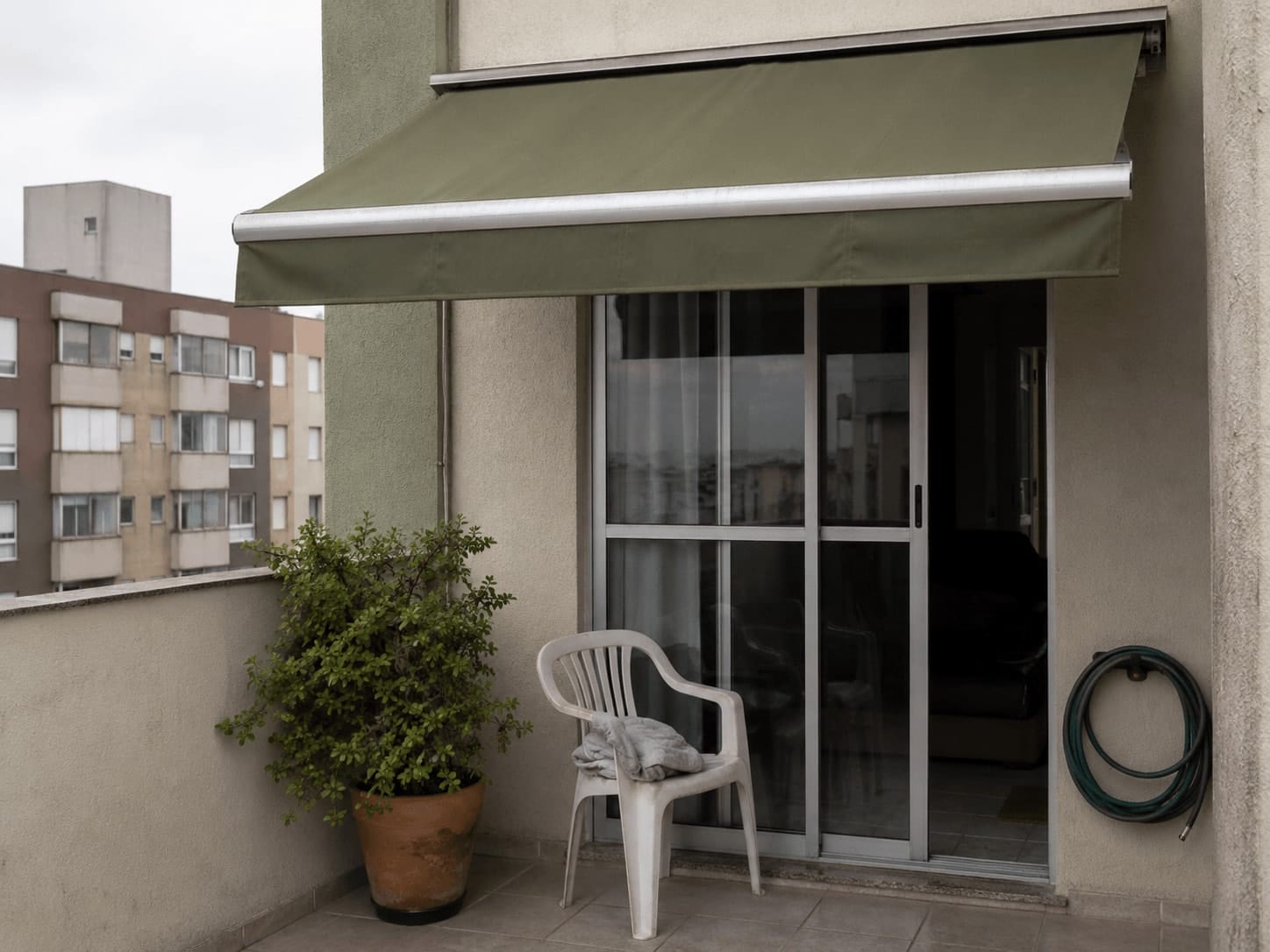 Toldo de lona instalado sobre porta de varanda em apartamento