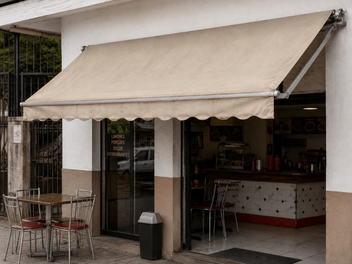 Toldo de lona usado em bom estado sobre fachada de pequeno comércio